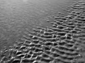 Interesting patterns created by receding water after a high tide on a sea beach.