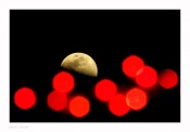 A moon captured with the bokeh of decorative series lights